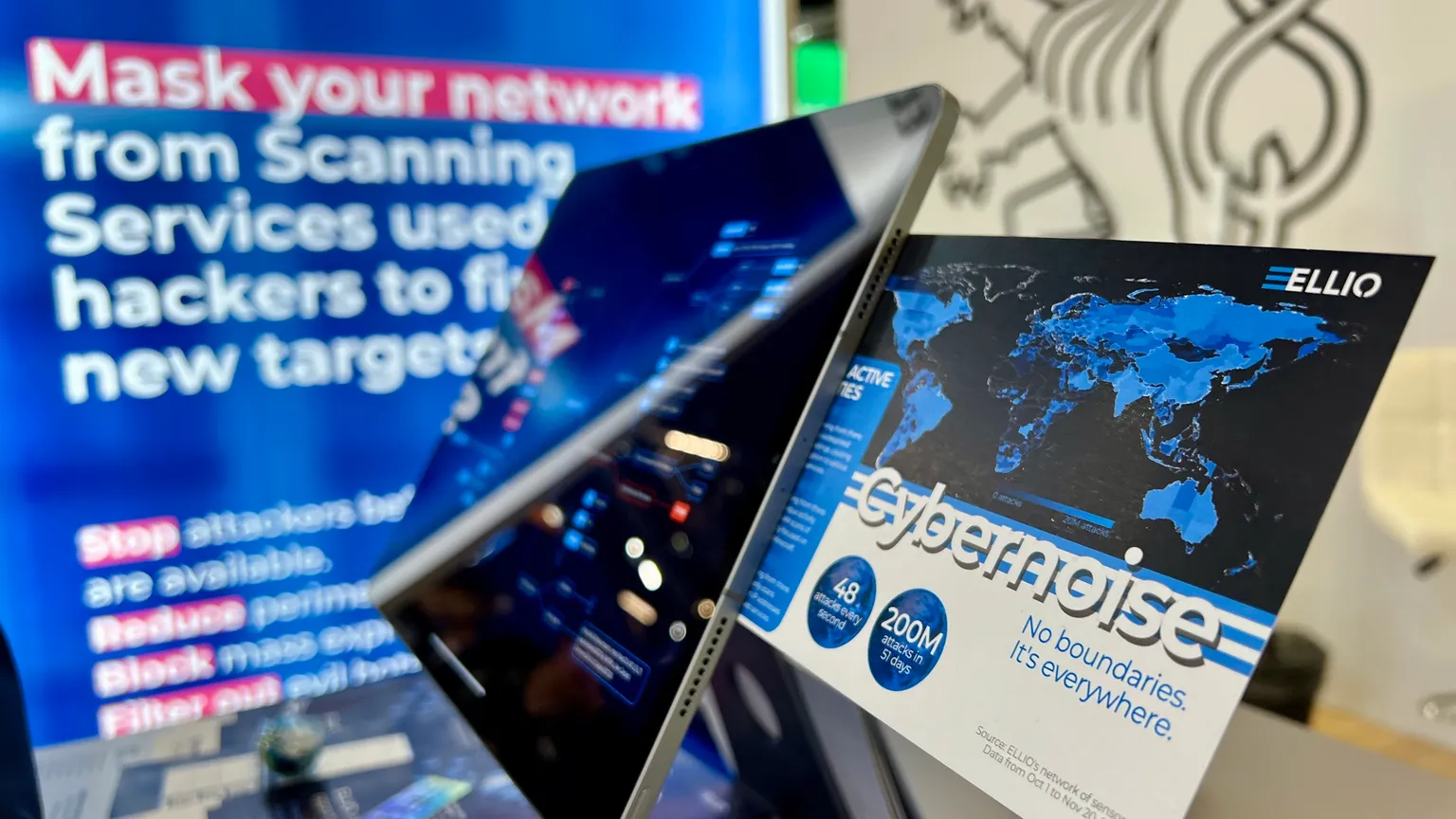 ELLIO cybersecurity dashboard showing global threat map with blue highlighted regions and "CyberNoise" threat intelligence data, alongside promotional text about masking networks from scanning services used by hackers