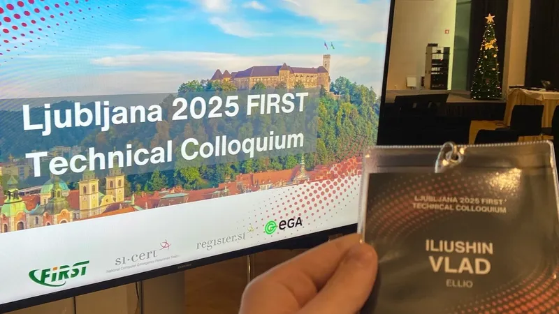 Hand holding conference badge for "Ljubljana 2025 FIRST Technical Colloquium" with name "ILUSHIN VLAD" from ELLIO, conference banner visible in background